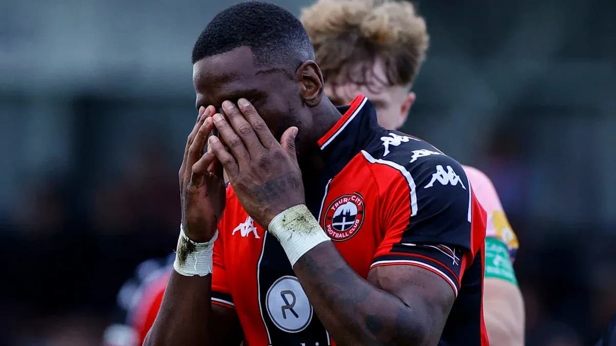 Player in red jersey holding face in disappointment Player in red jersey holding face in disappointment
