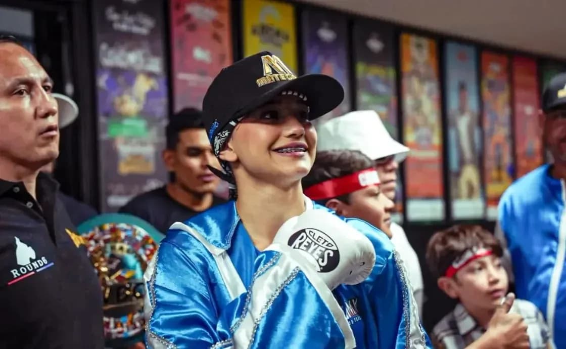 Young boxer smiling with gloves and team members Young boxer smiling with gloves and team members