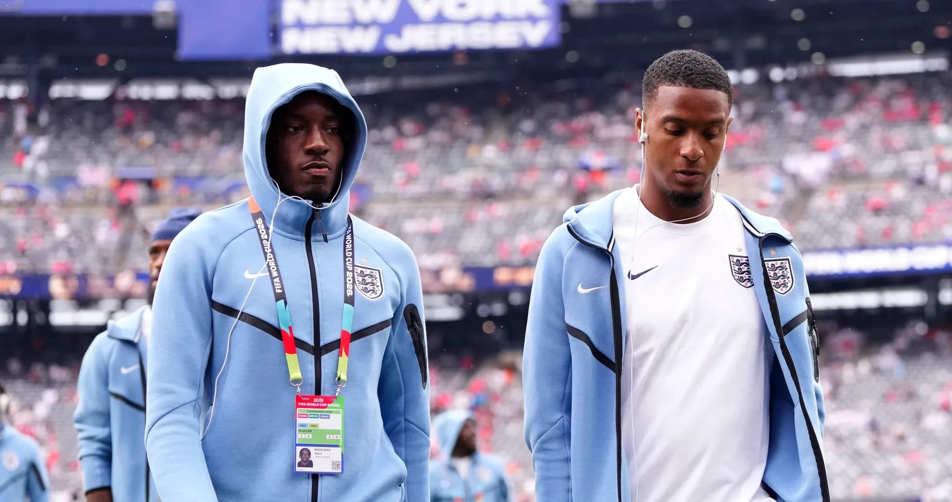 Two England players walking on stadium field Two England players walking on stadium field