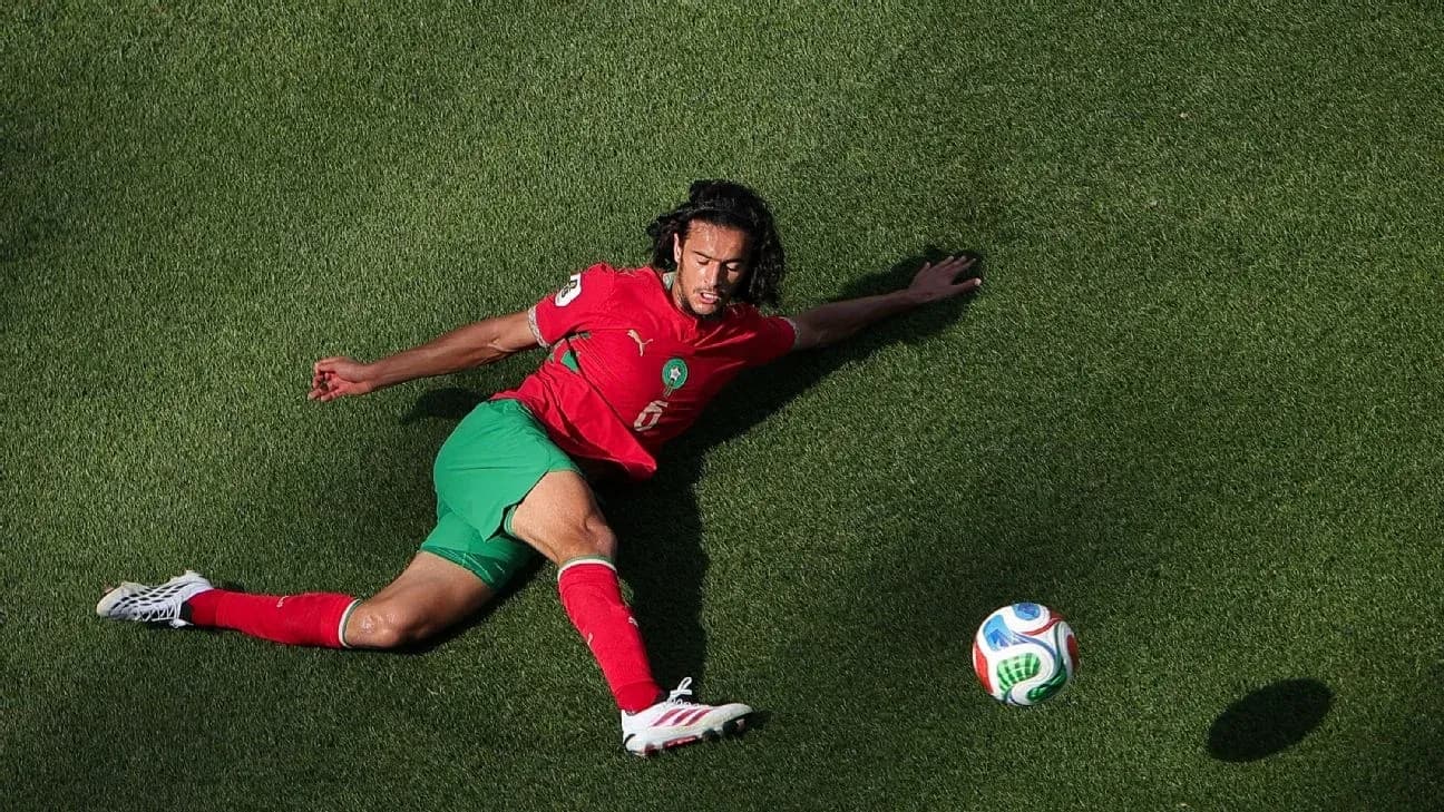 Moroccan player sliding on grass after ball Moroccan player sliding on grass after ball