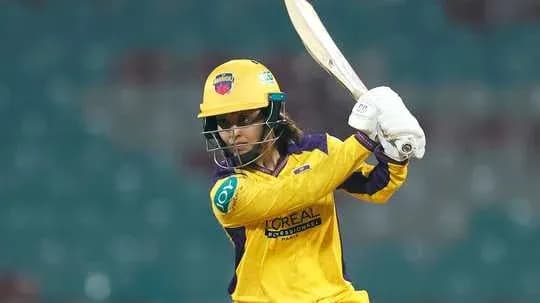Batsman in yellow uniform preparing to hit ball Batsman in yellow uniform preparing to hit ball