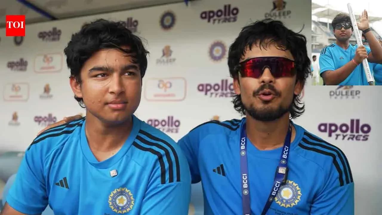 Two young cricketers in blue jerseys at press conference Two young cricketers in blue jerseys at press conference