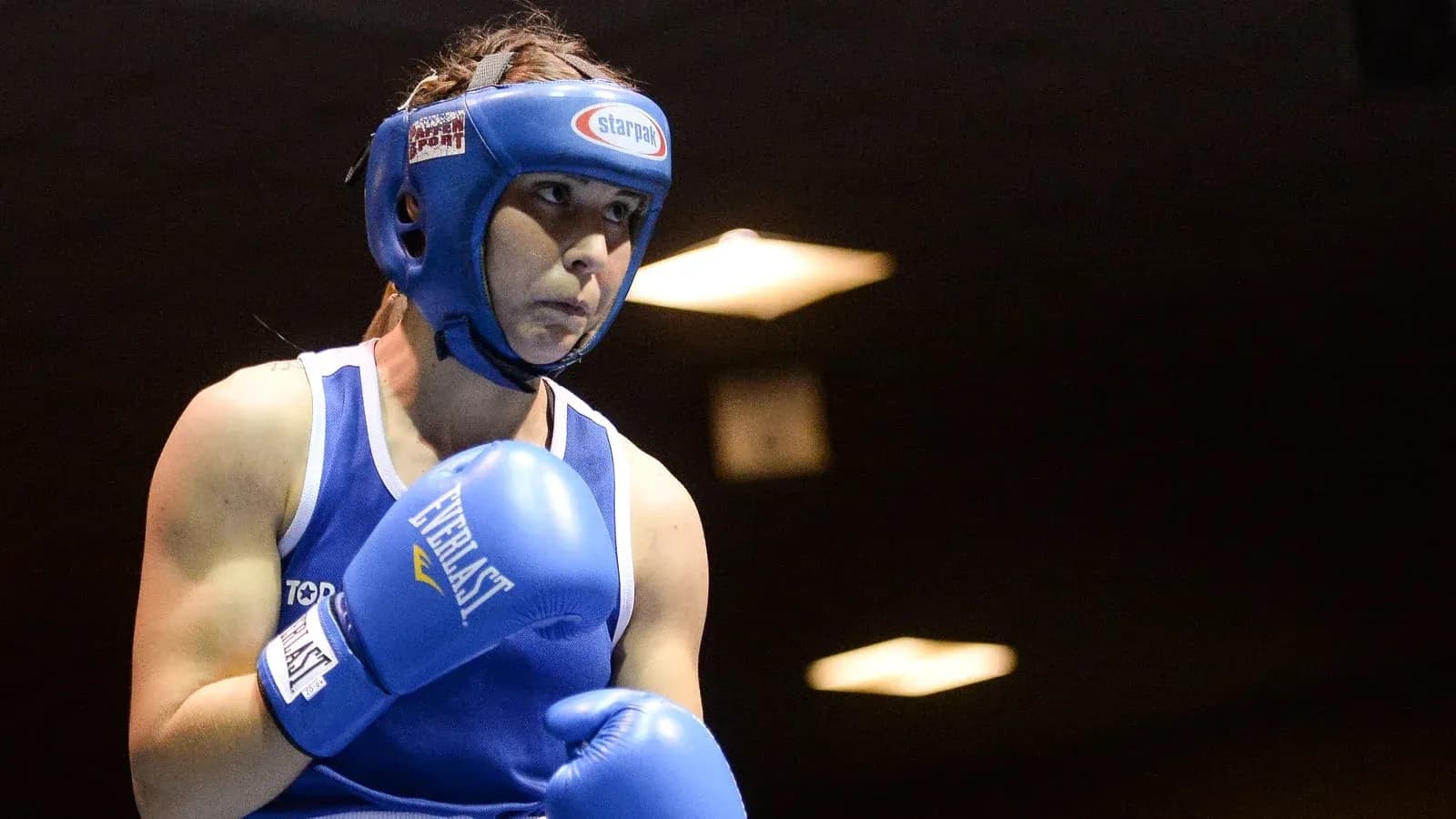 Female boxer preparing for a match in blue gear Female boxer preparing for a match in blue gear