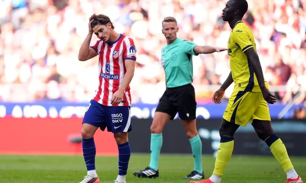 Atletico Madrid player reacts during match with referee Atletico Madrid player reacts during match with referee