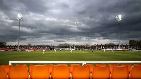 Cricket match in progress under cloudy skies Cricket match in progress under cloudy skies