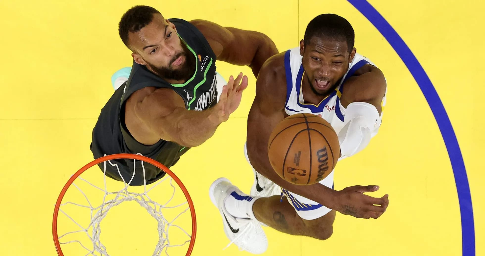 Player attempting a shot while defended under the basket Player attempting a shot while defended under the basket
