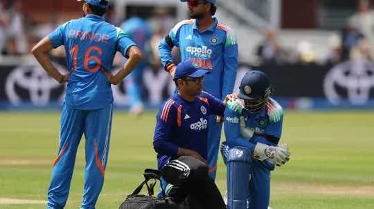 Player receiving medical attention during cricket match Player receiving medical attention during cricket match