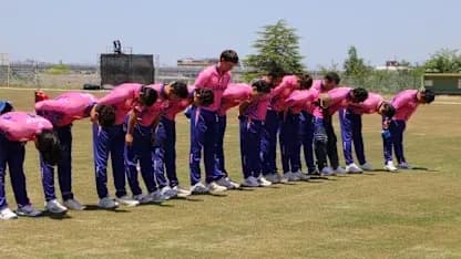 Cricket team bowing in unison on practice field Cricket team bowing in unison on practice field