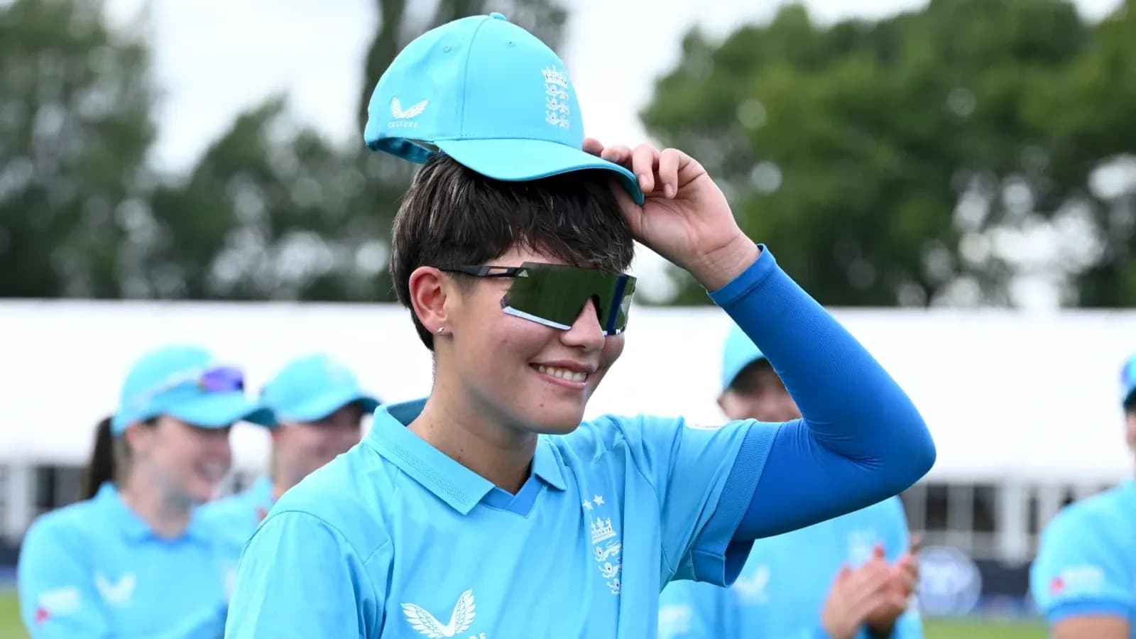 Player adjusting cap during team event outdoors Player adjusting cap during team event outdoors