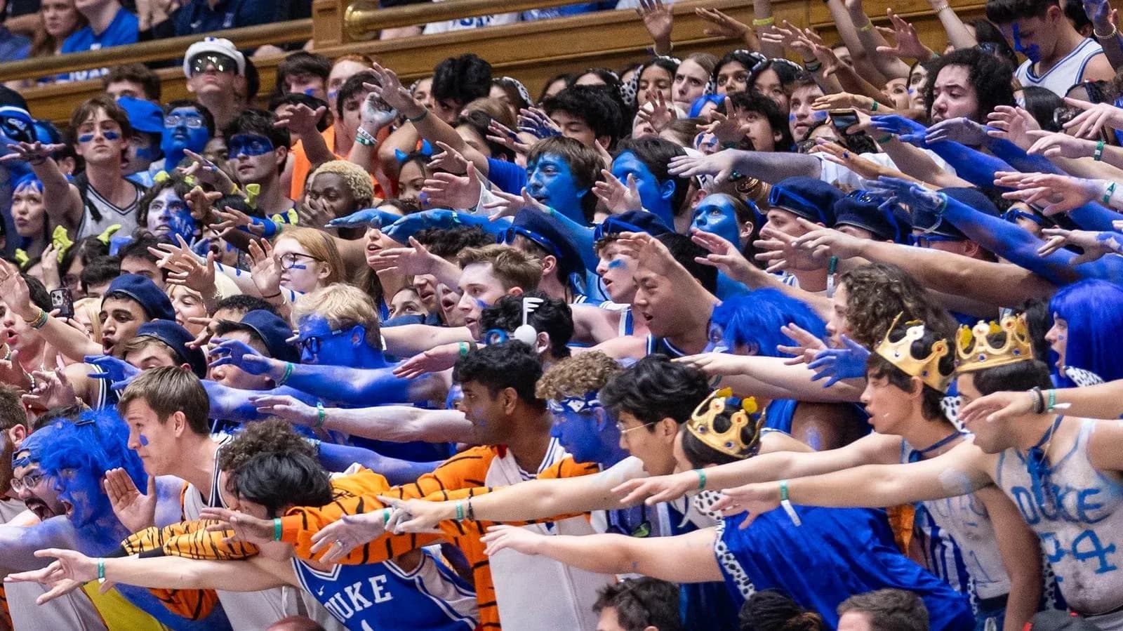 Duke fans in blue paint cheering at game Duke fans in blue paint cheering at game