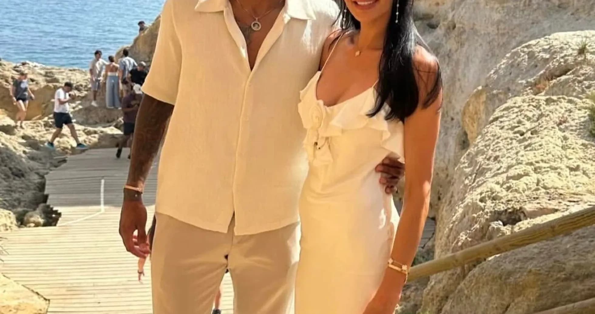 Couple posing on beachside pathway with cliffs Couple posing on beachside pathway with cliffs