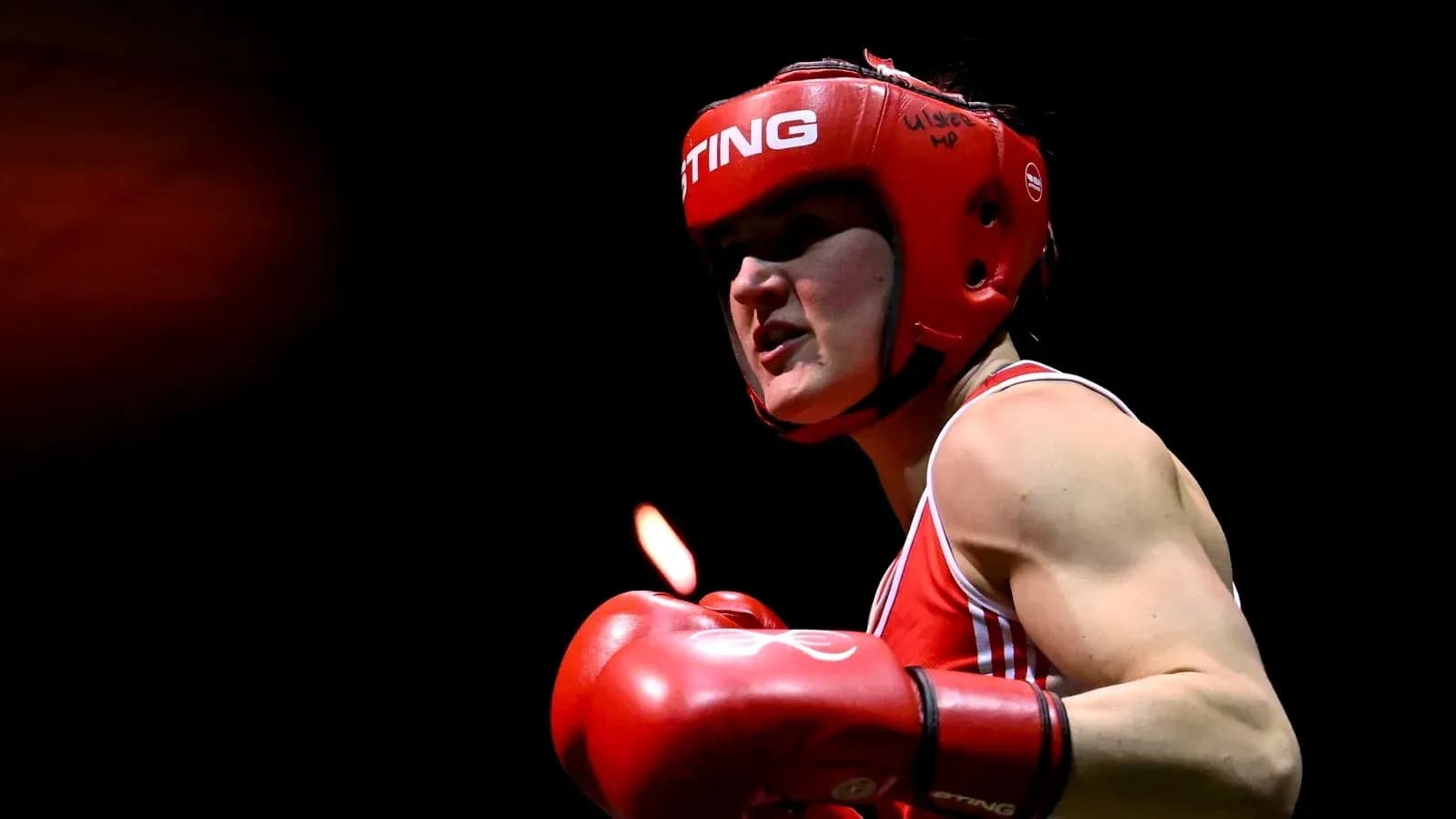 Female boxer in red gear preparing to strike Female boxer in red gear preparing to strike