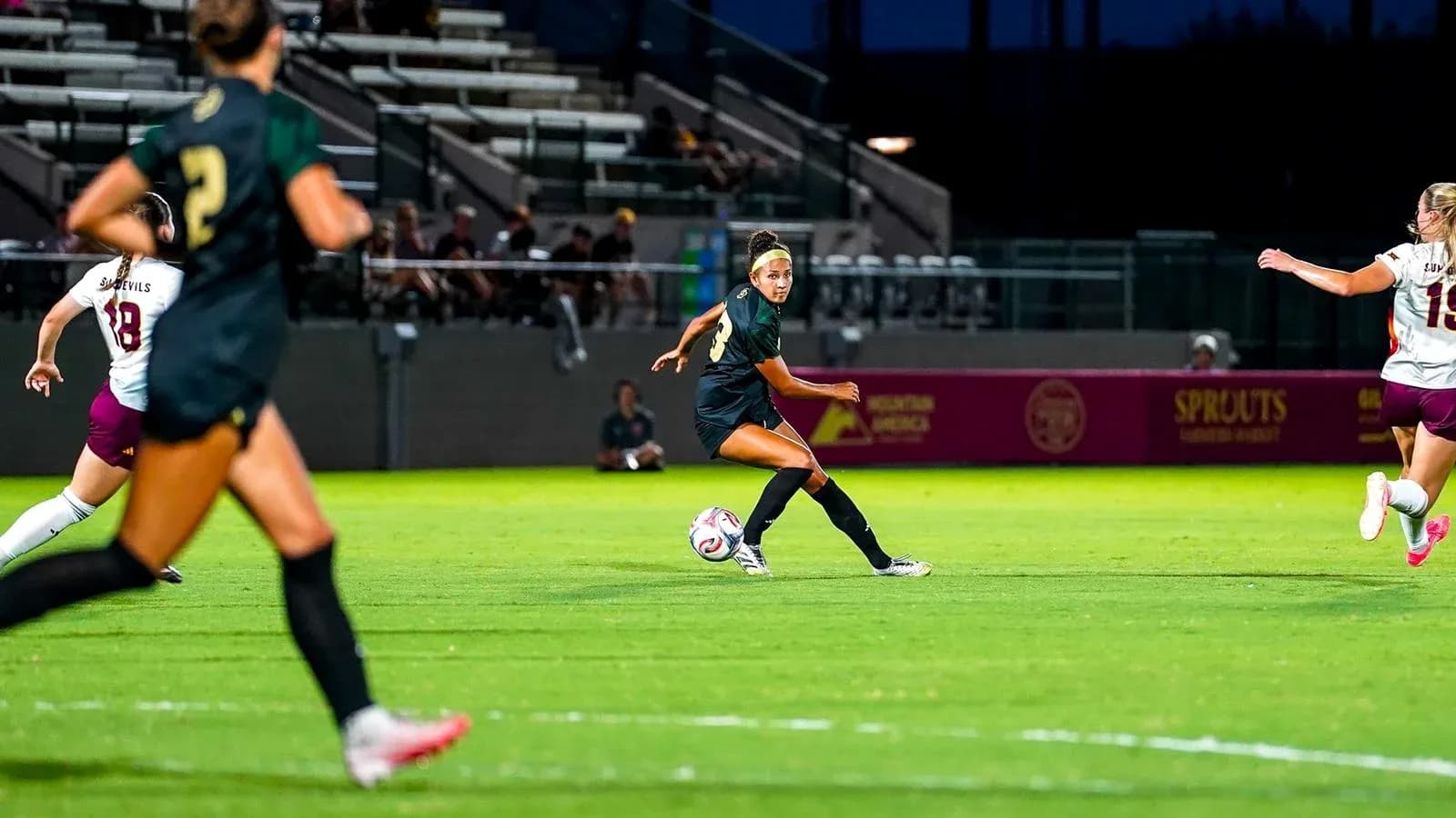 Player passing ball during soccer match at night Player passing ball during soccer match at night