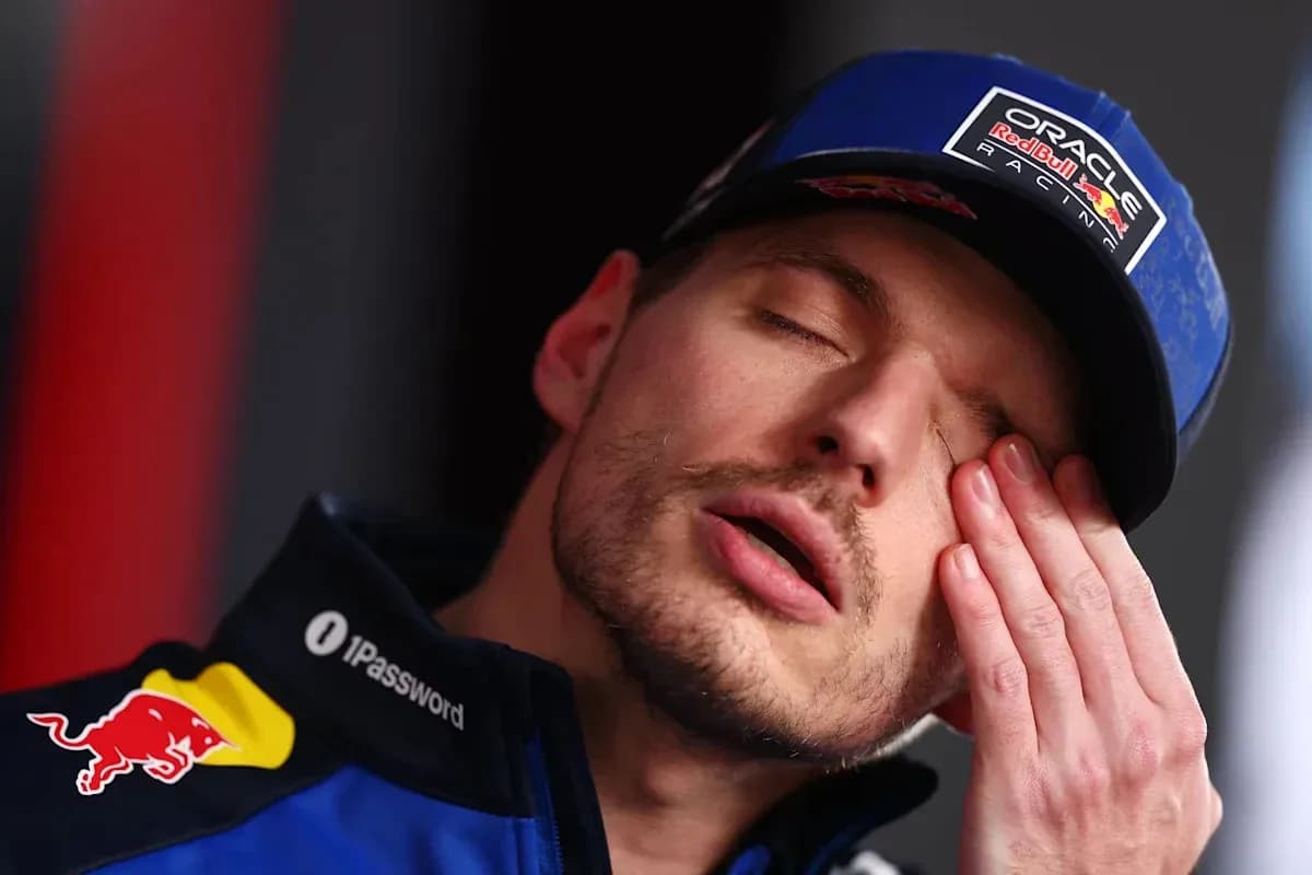 Racing driver with hand on face during press event Racing driver with hand on face during press event