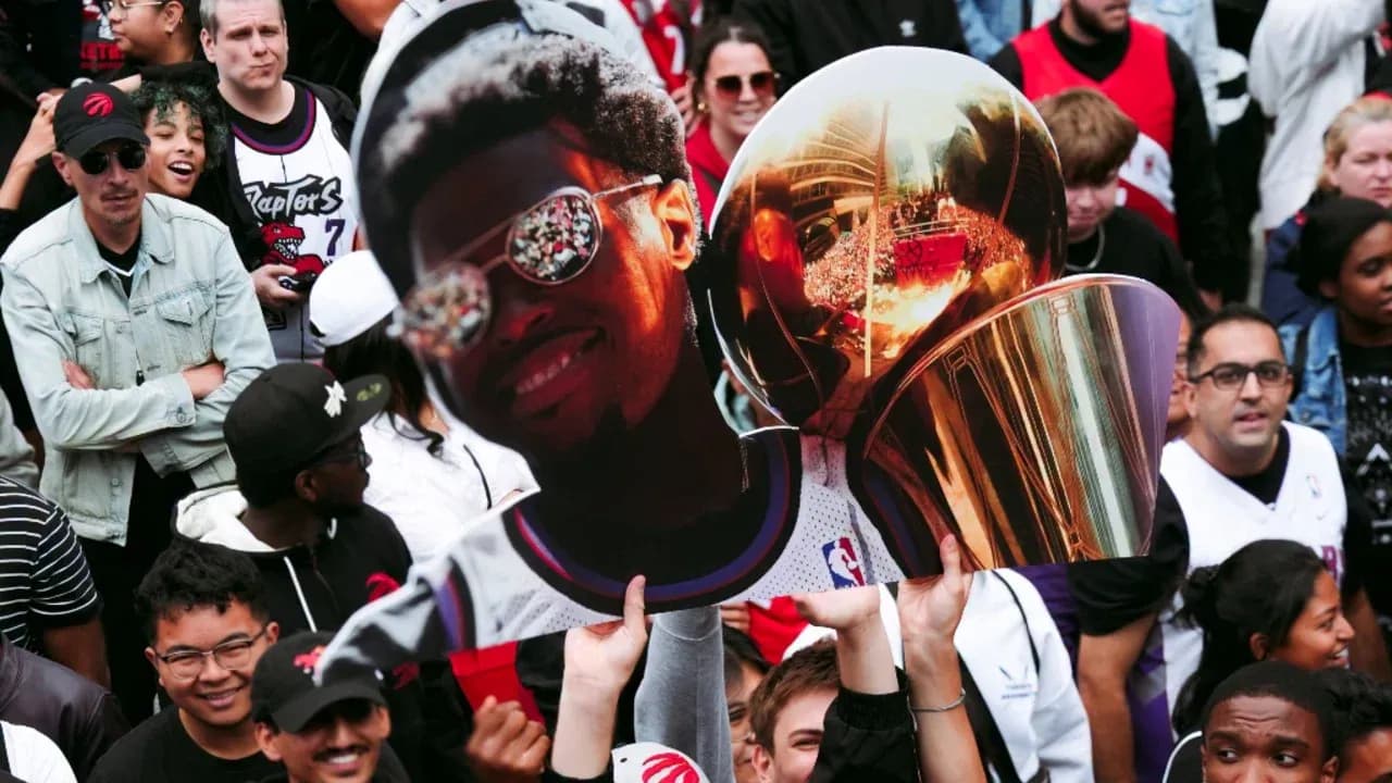 Fans holding large cutout and trophy at celebration Fans holding large cutout and trophy at celebration