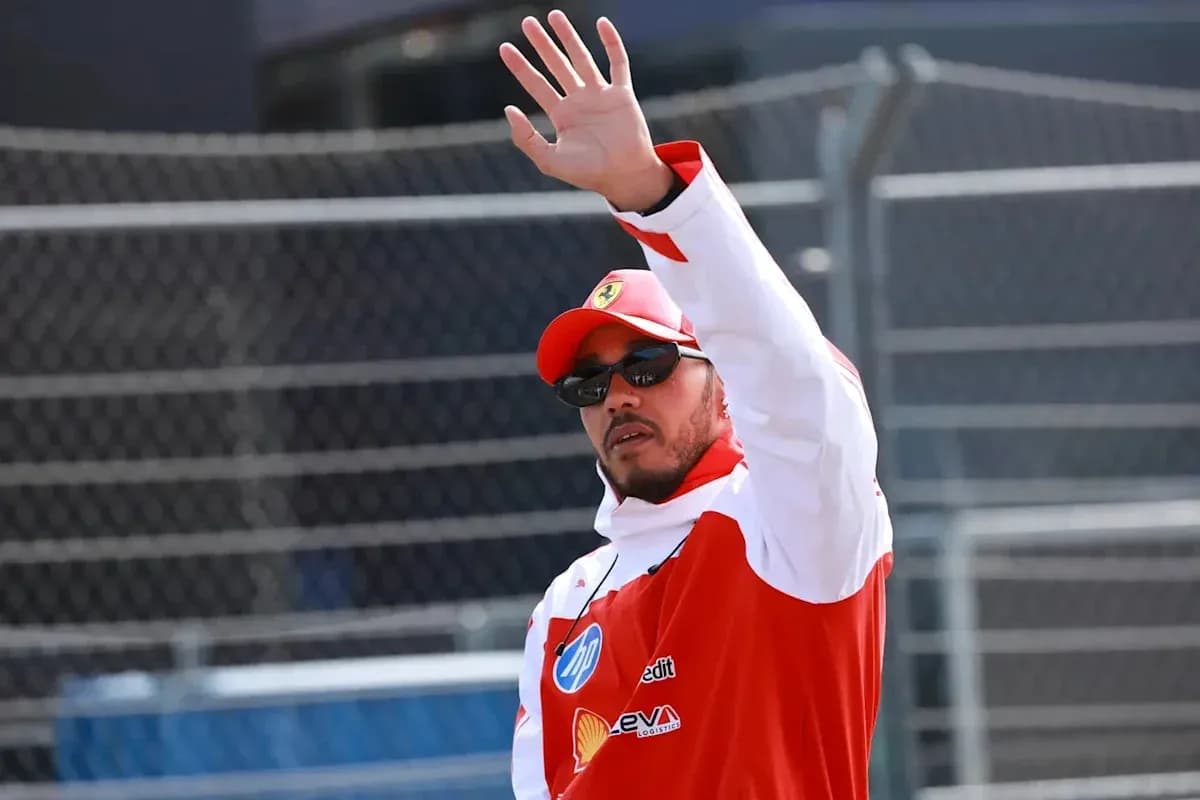 Driver waving while wearing racing gear and sunglasses Driver waving while wearing racing gear and sunglasses