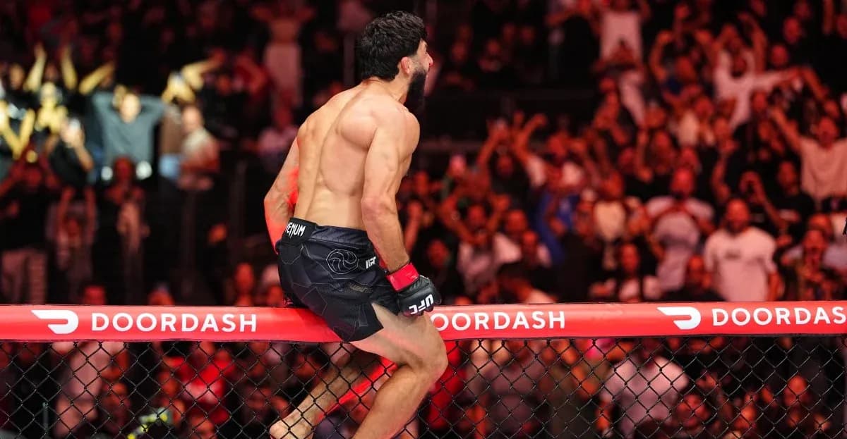 Fighter celebrating on the octagon fence after victory Fighter celebrating on the octagon fence after victory
