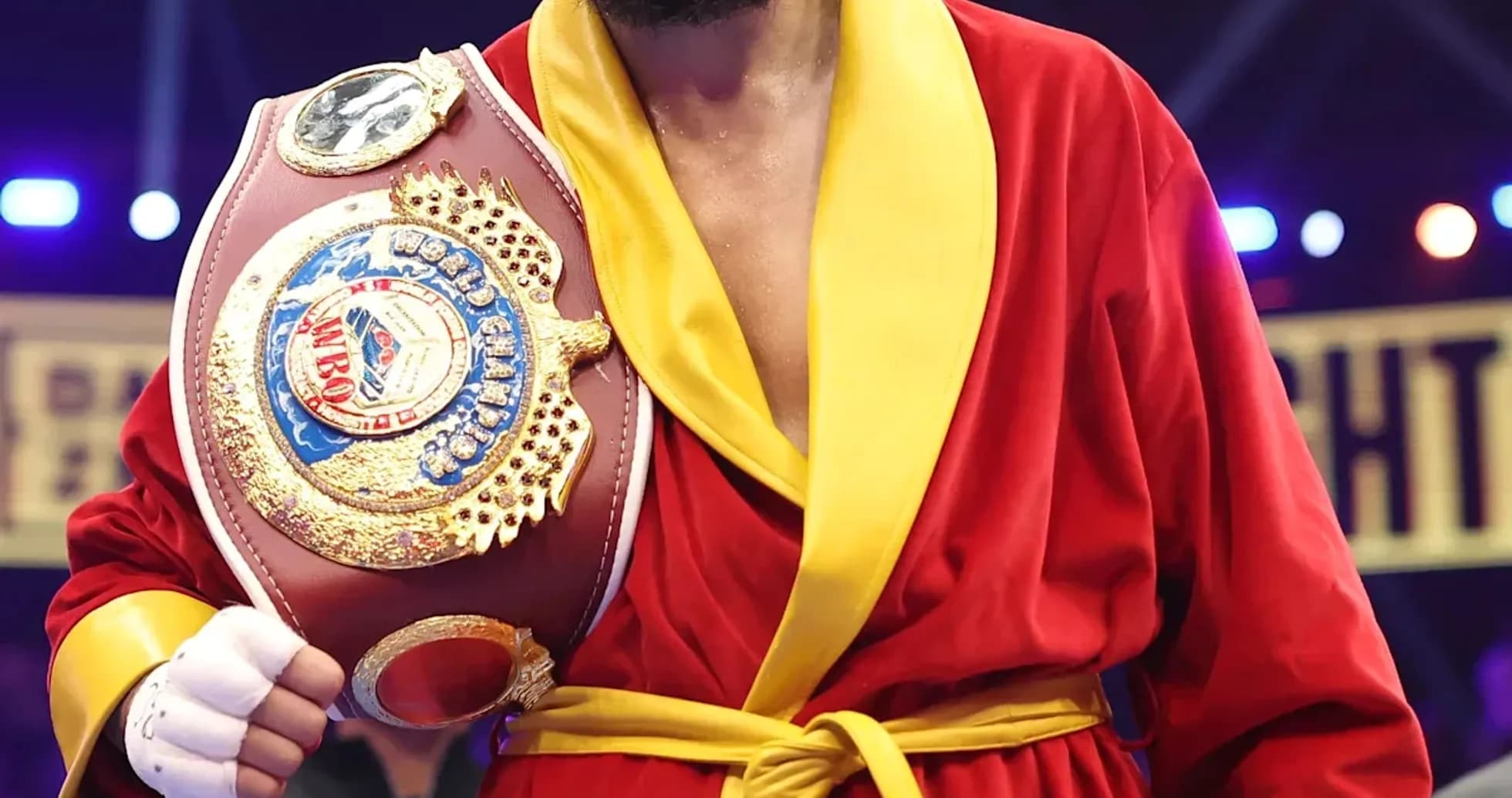 Boxer wearing red robe holding championship belt Boxer wearing red robe holding championship belt