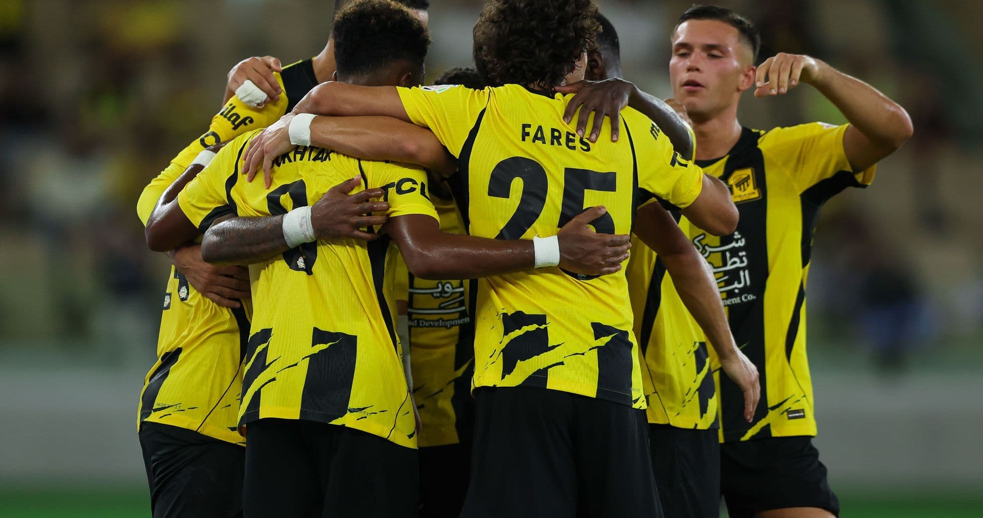 Players celebrating a goal in yellow uniforms Players celebrating a goal in yellow uniforms