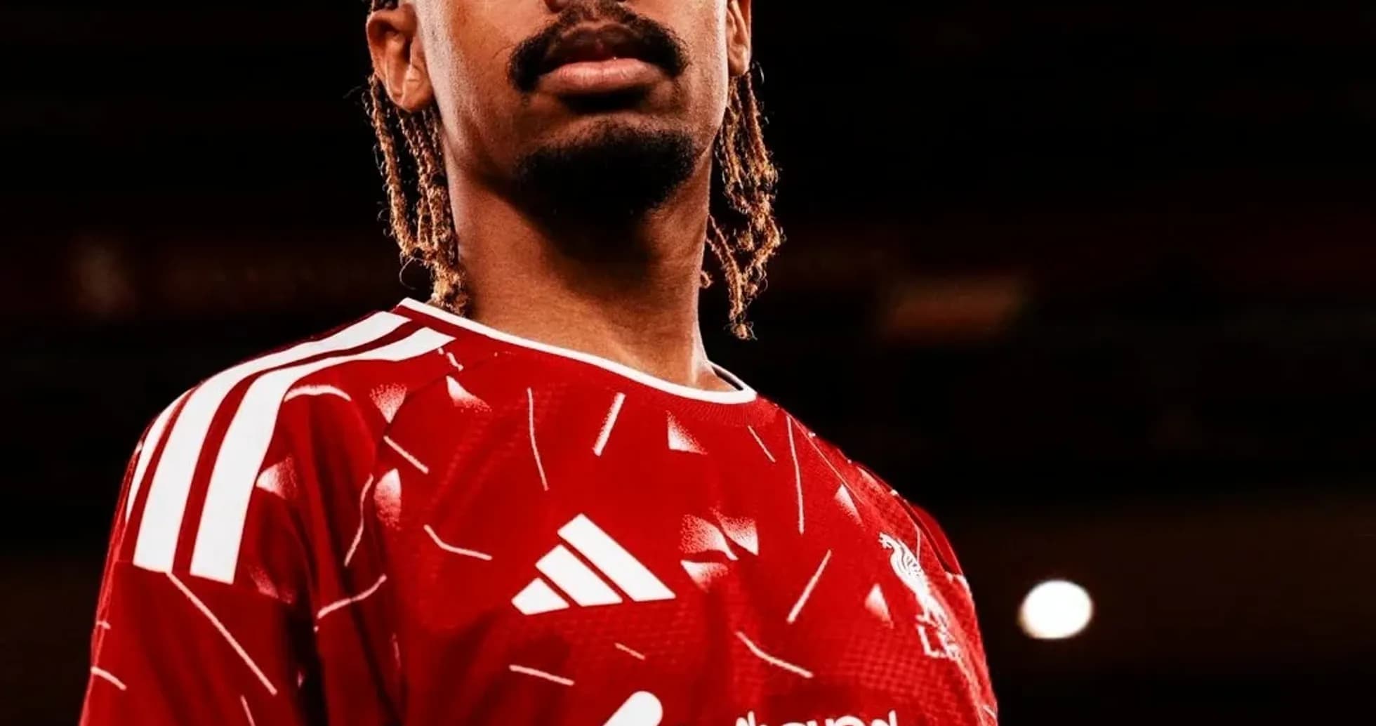 Player posing in red football kit with sponsor logo Player posing in red football kit with sponsor logo