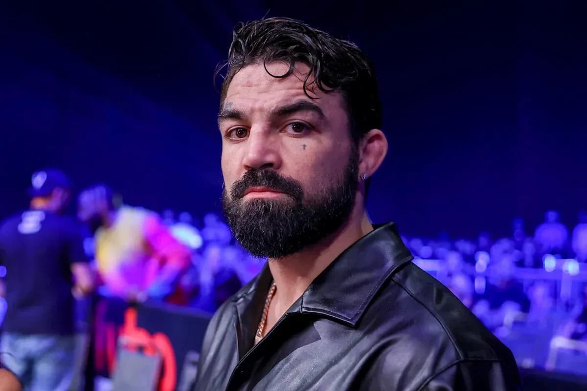 Man with beard in a dark jacket at event Man with beard in a dark jacket at event