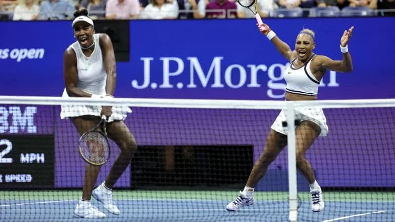 Venus and Serena Williams celebrating on court Venus and Serena Williams celebrating on court