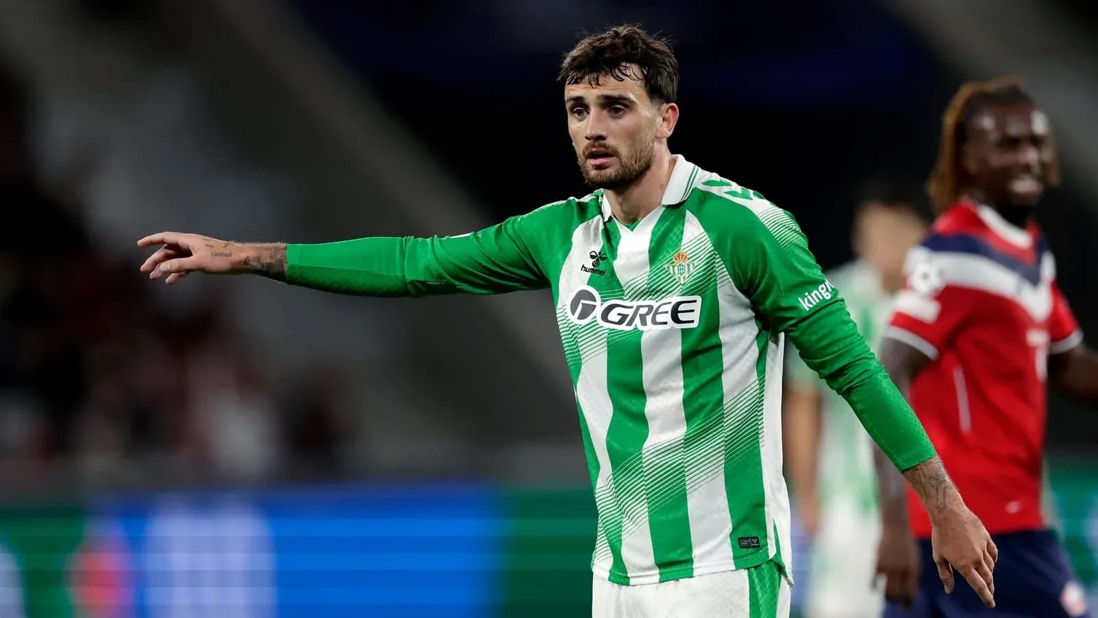 Player in green and white jersey gesturing on field Player in green and white jersey gesturing on field