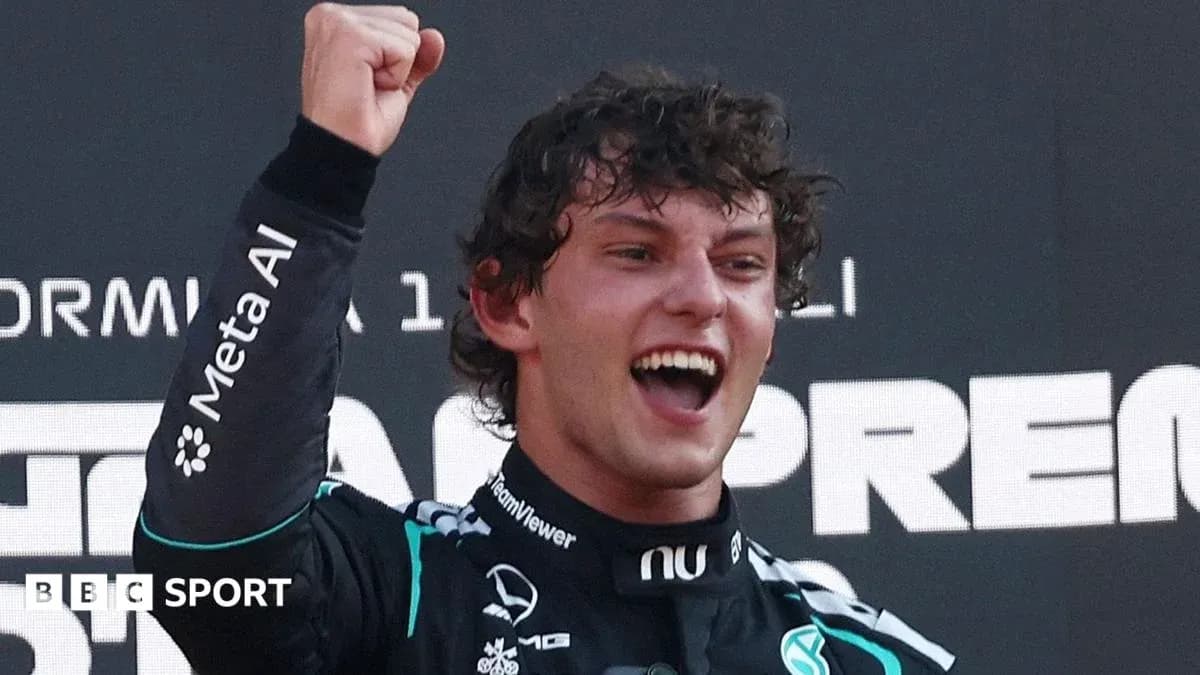 Driver celebrating victory with raised fist on podium Driver celebrating victory with raised fist on podium