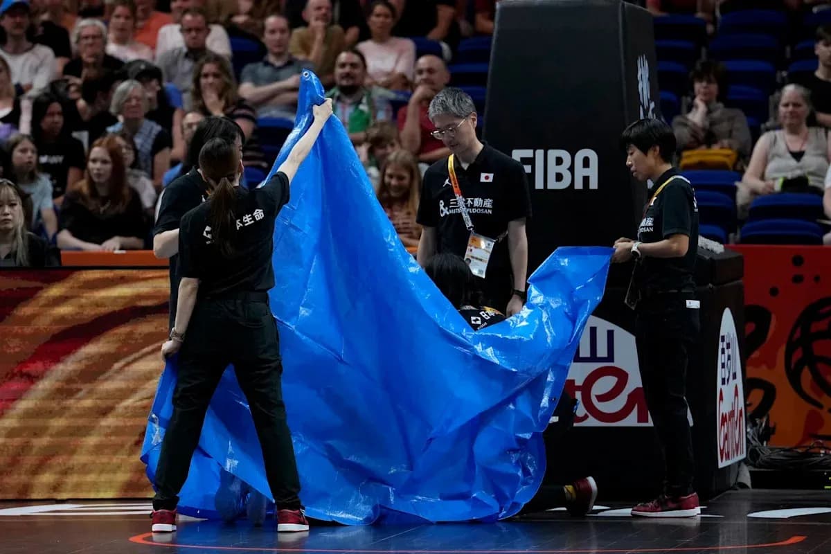 Crew covering court with blue tarp during event Crew covering court with blue tarp during event