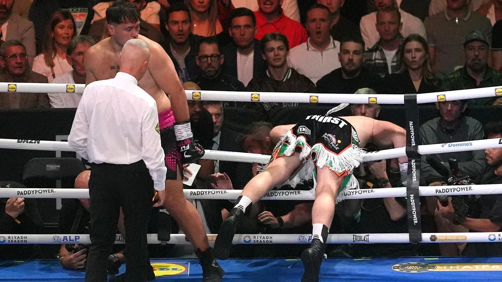 Boxer knocked down, referee checking on the fighters Boxer knocked down, referee checking on the fighters