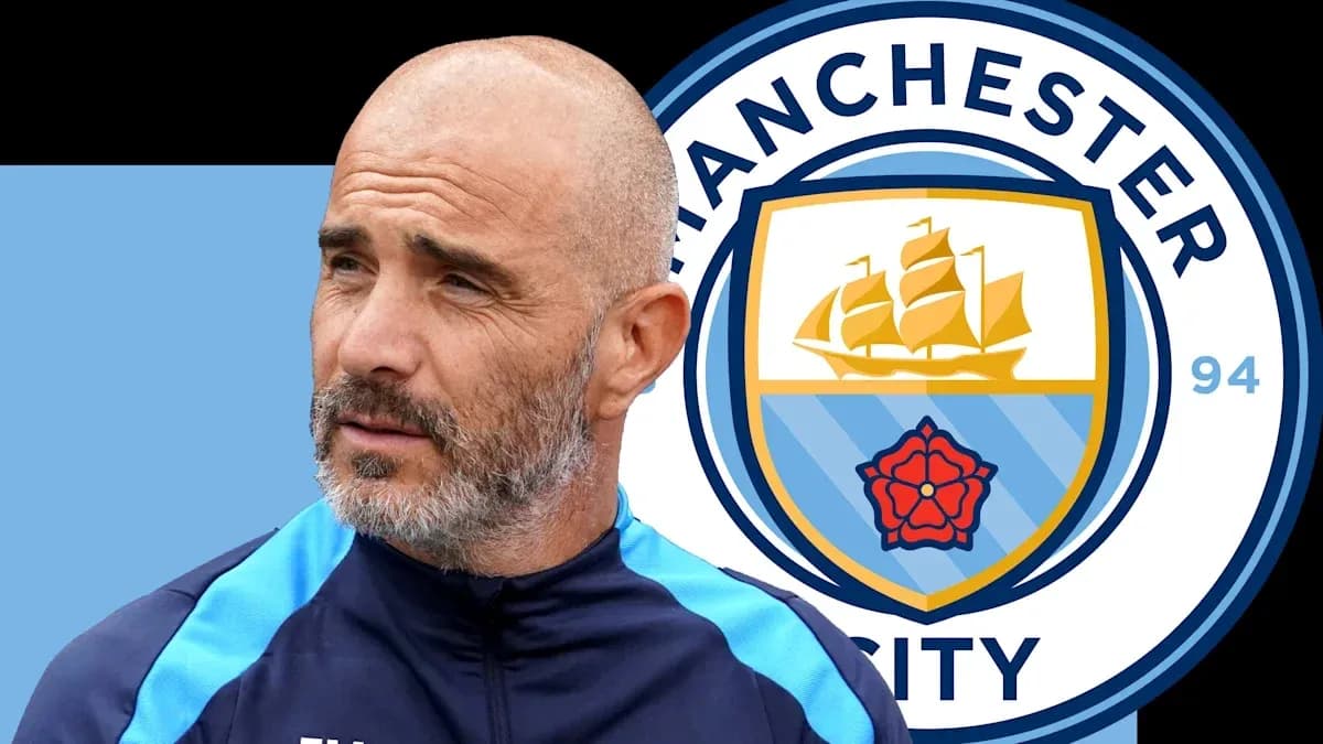 Coach standing next to Manchester City logo Coach standing next to Manchester City logo