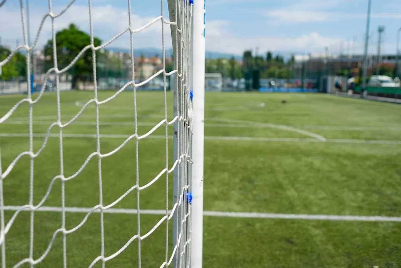 Close-up of soccer goal with field background Close-up of soccer goal with field background