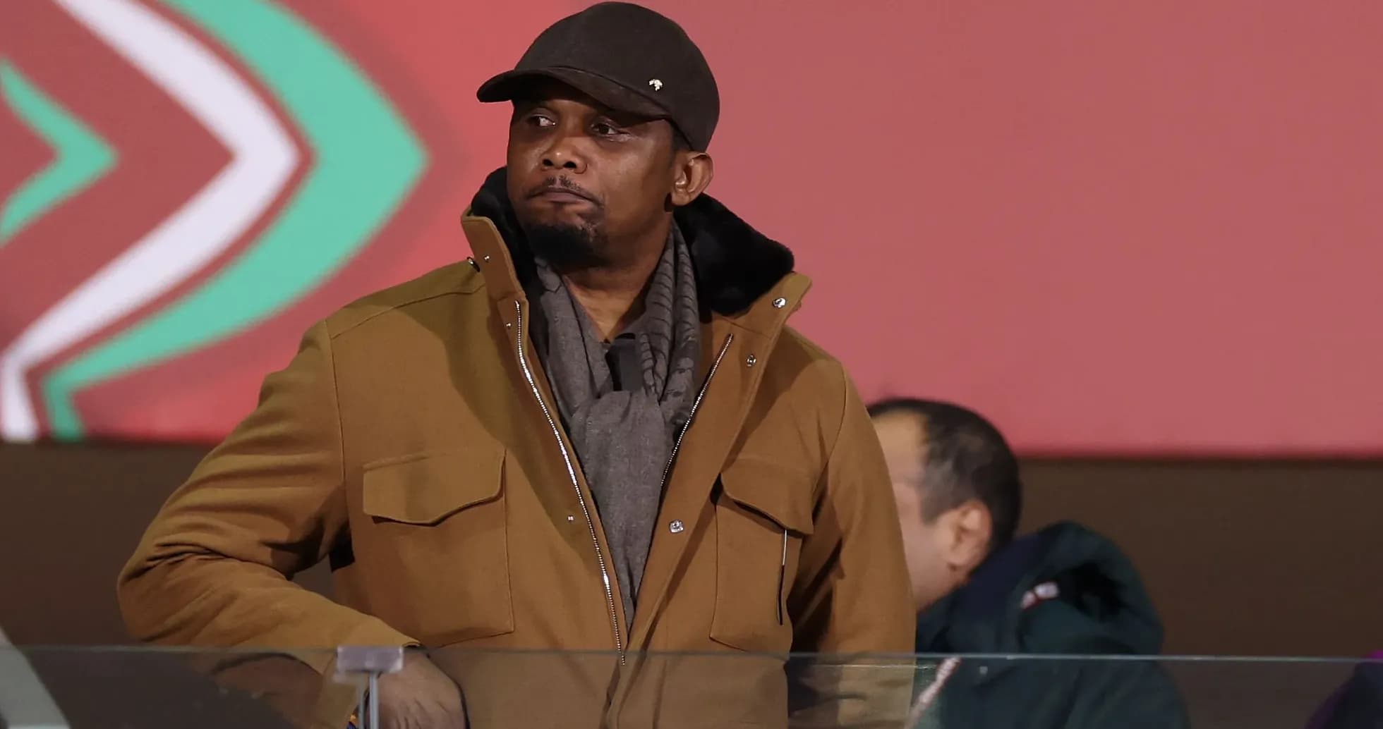 Man in brown coat observing an event Man in brown coat observing an event
