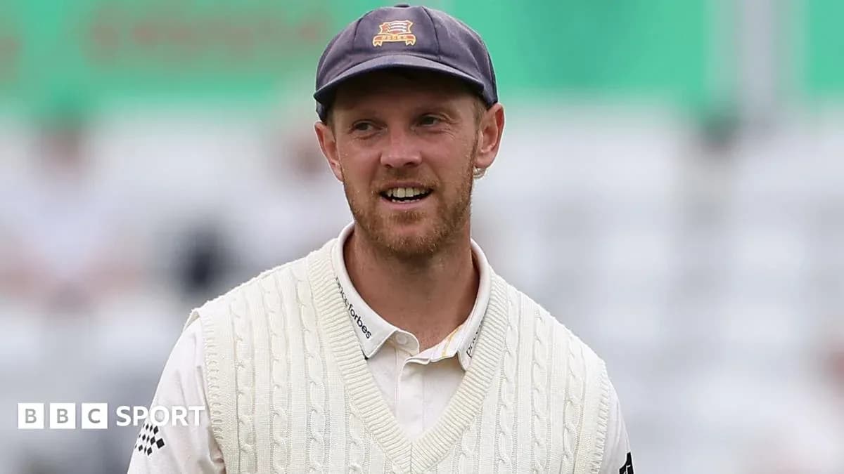 Cricketer wearing a white sweater and cap Cricketer wearing a white sweater and cap