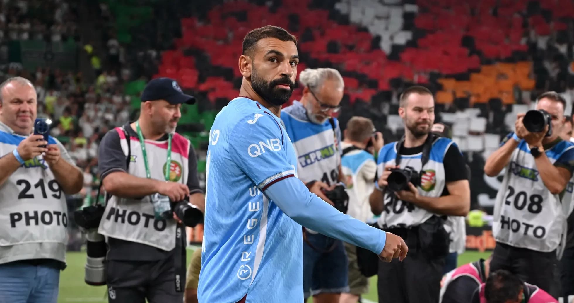 Player walking past photographers on the field Player walking past photographers on the field