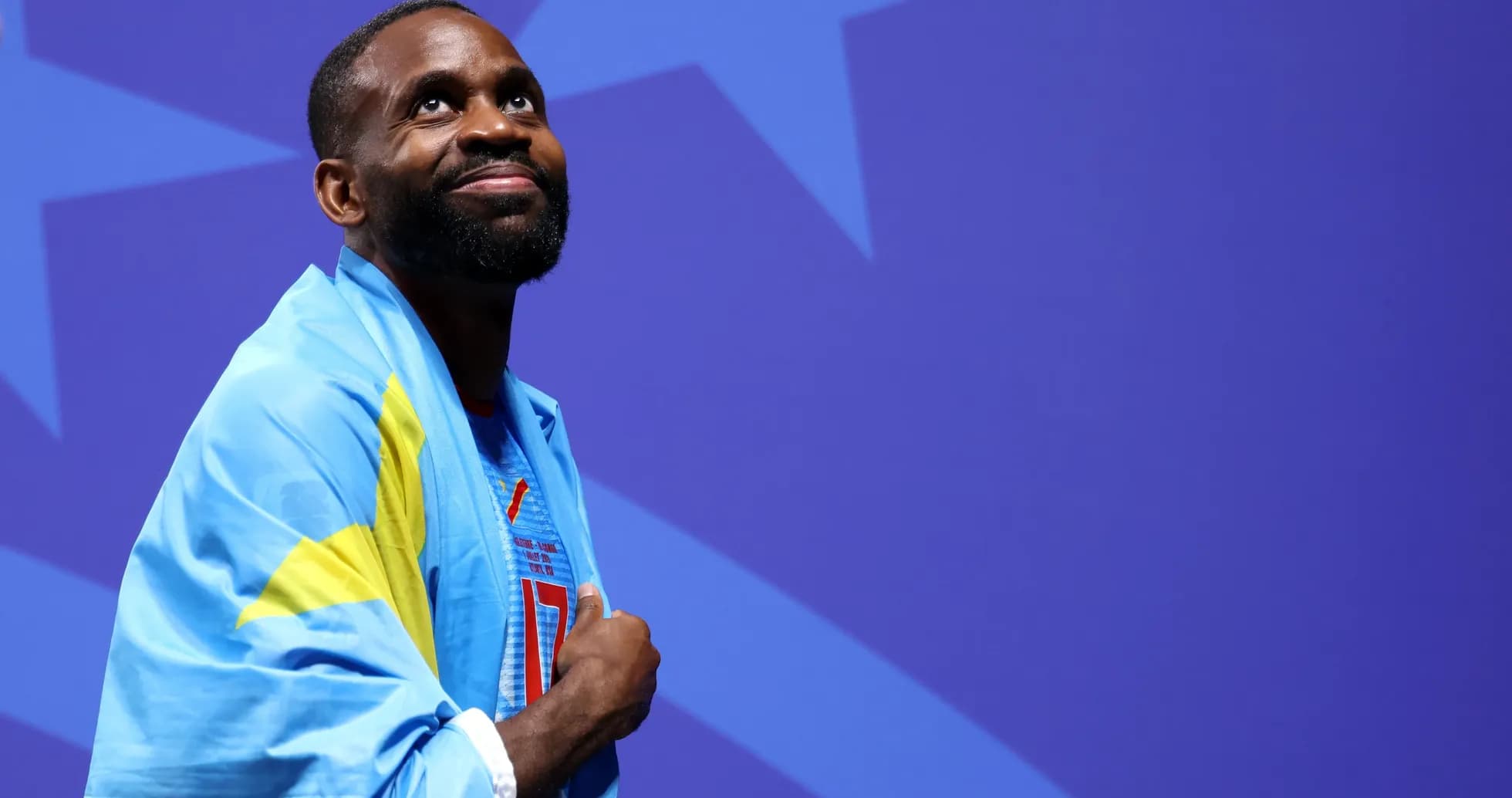 Athlete wearing a blue flag and smiling Athlete wearing a blue flag and smiling
