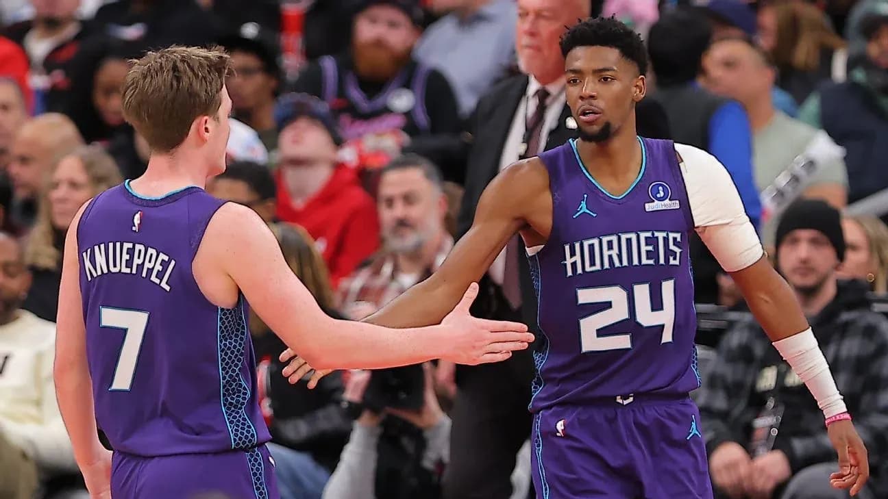 Two Hornets players exchanging a handshake on court Two Hornets players exchanging a handshake on court