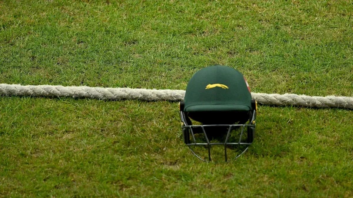 Cricket helmet resting on grass near boundary rope Cricket helmet resting on grass near boundary rope