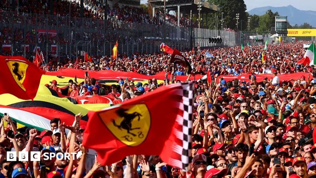 Crowd of fans waving Ferrari flags at event Crowd of fans waving Ferrari flags at event