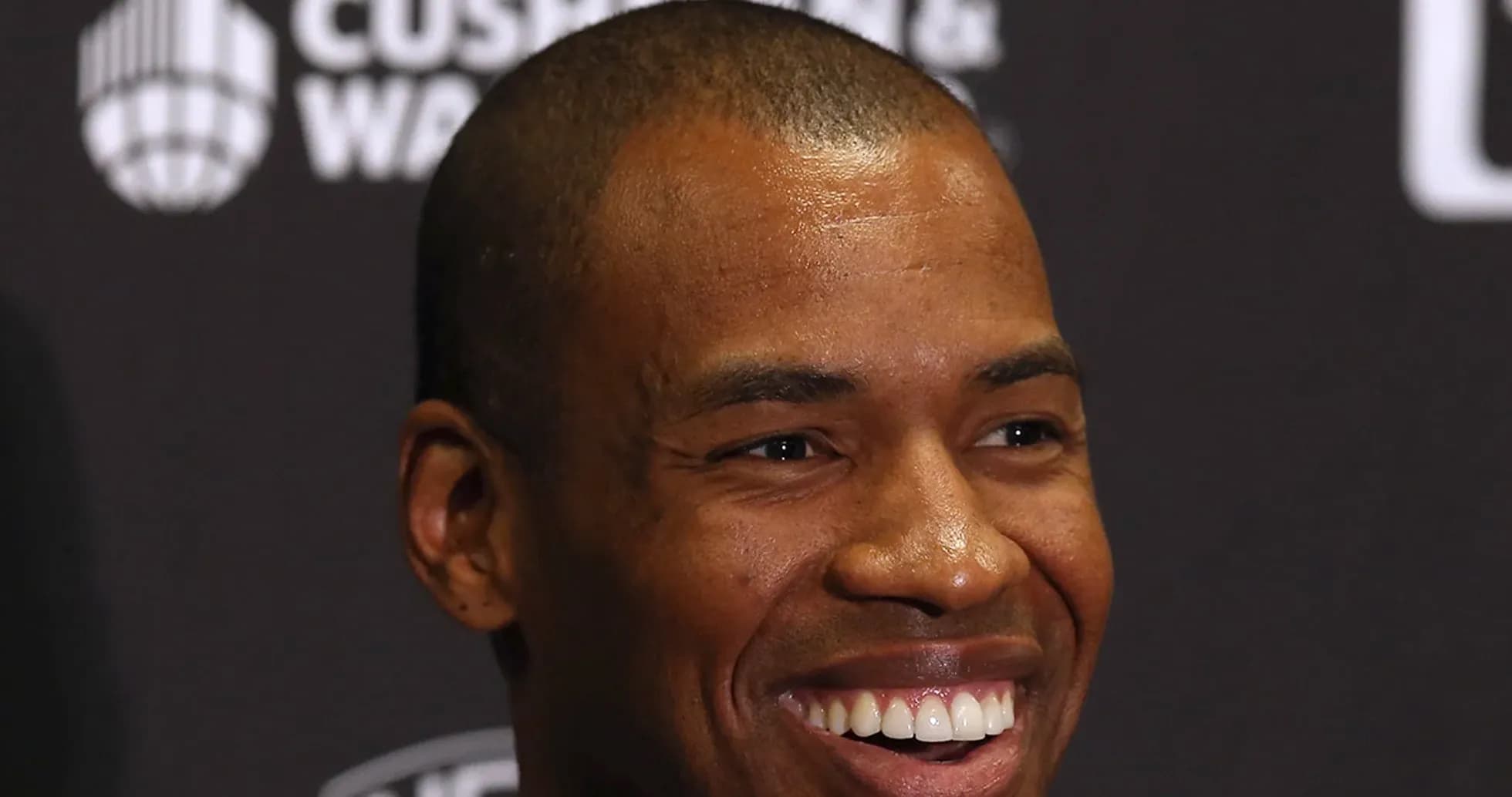 Smiling man at press conference with dark background Smiling man at press conference with dark background