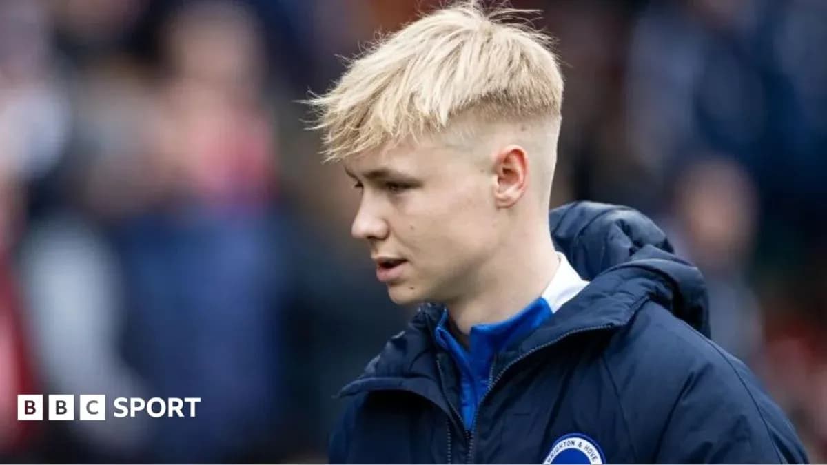 Player in team jacket walking on field Player in team jacket walking on field