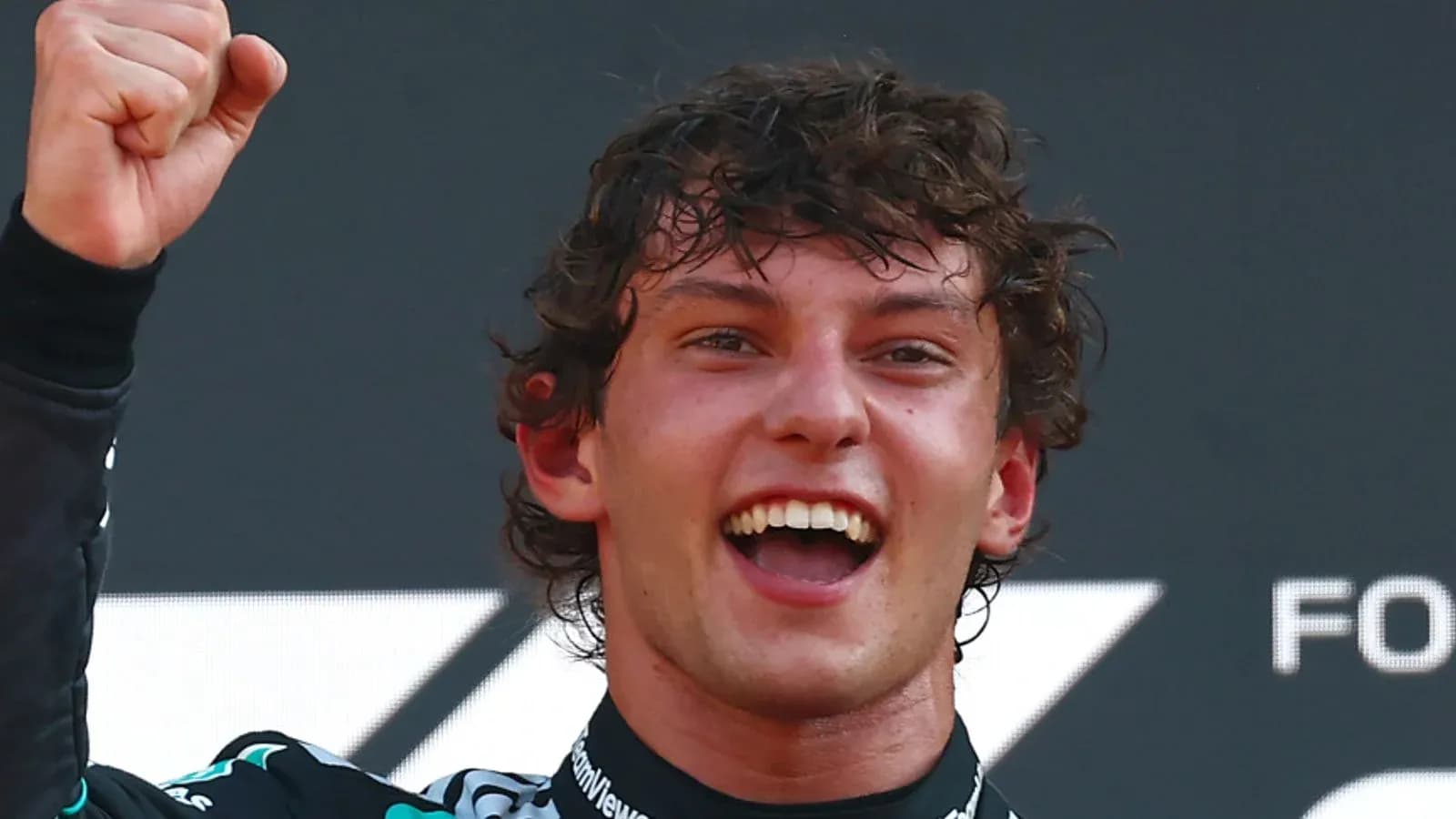 Racer celebrating victory with raised fist and smile Racer celebrating victory with raised fist and smile