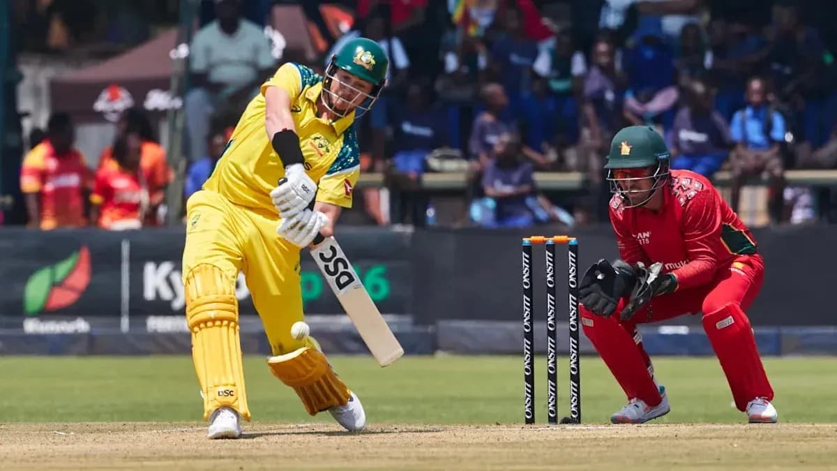 Batsman hitting ball while wicketkeeper prepares to catch Batsman hitting ball while wicketkeeper prepares to catch