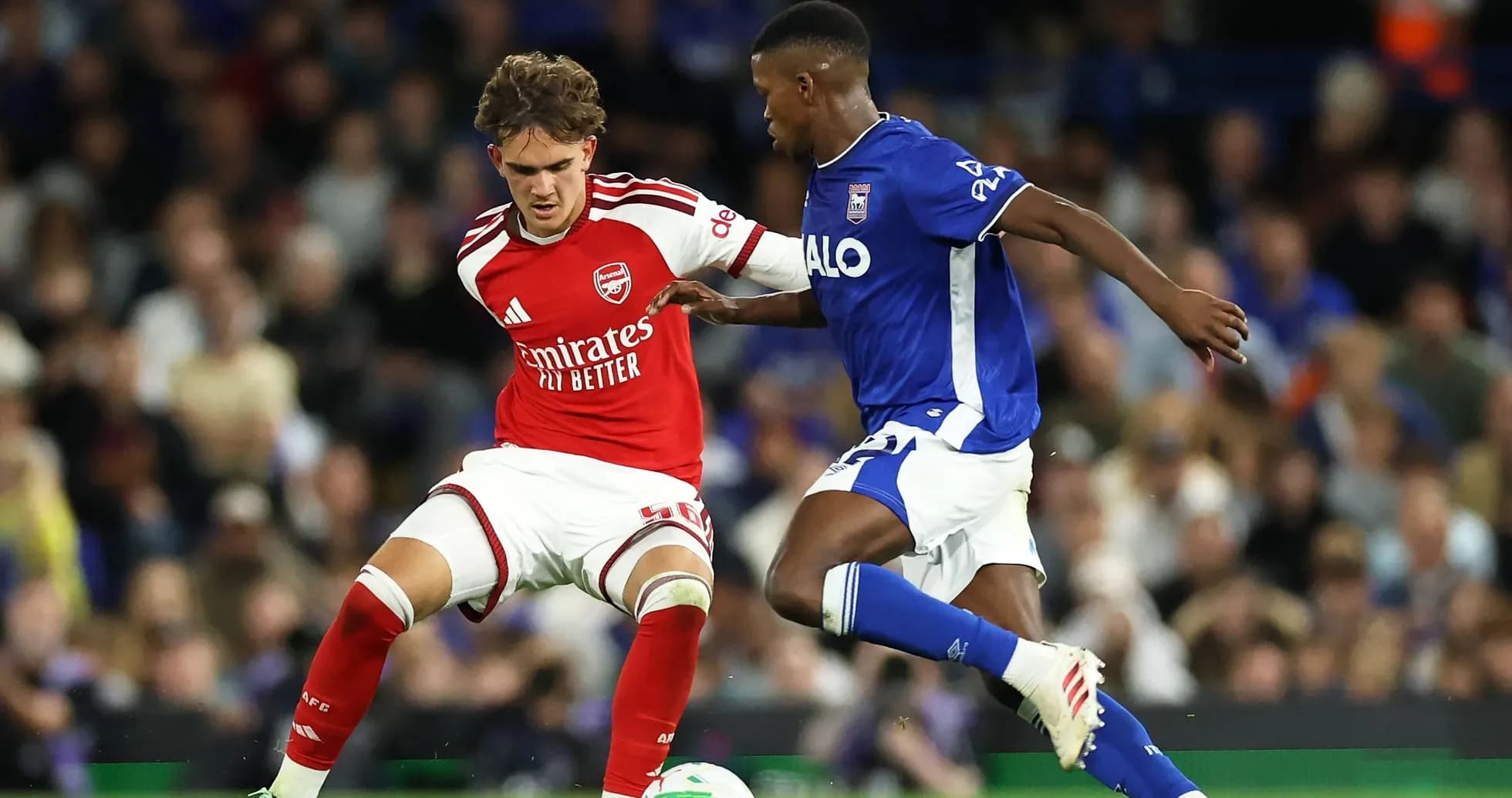Player in red and player in blue contesting the ball Player in red and player in blue contesting the ball