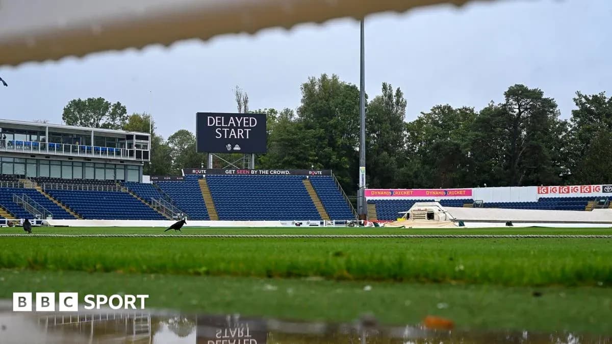 Cricket ground with delayed start sign and empty stands Cricket ground with delayed start sign and empty stands