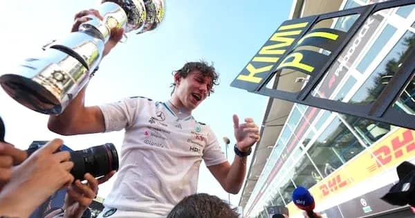 Driver celebrating with trophy after race victory Driver celebrating with trophy after race victory