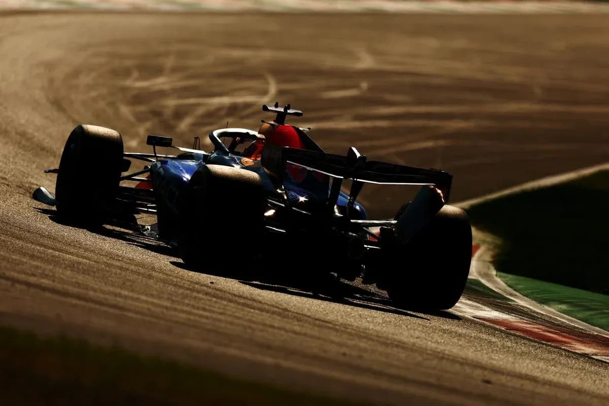 Formula 1 car navigating a curve on track Formula 1 car navigating a curve on track