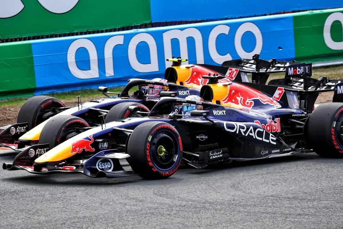 Two Red Bull Racing cars racing on track Two Red Bull Racing cars racing on track