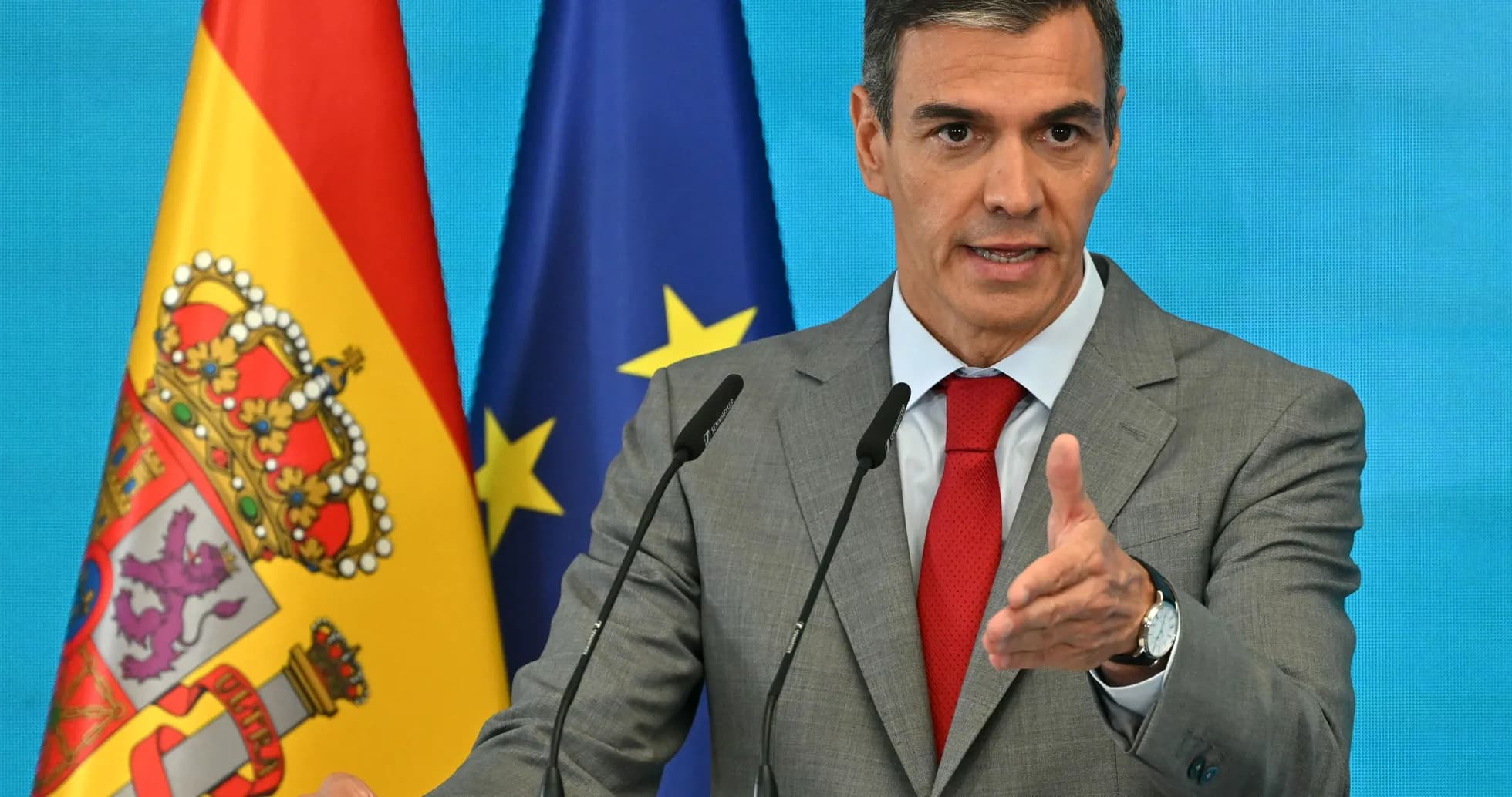 Man speaking at podium with flags behind Man speaking at podium with flags behind
