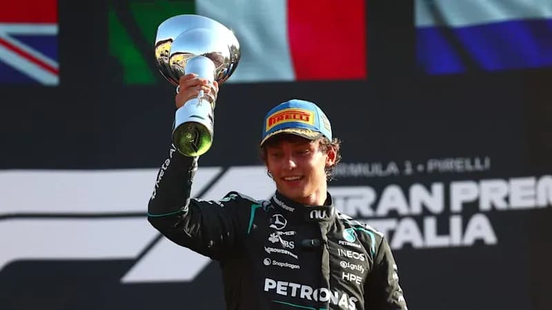 Driver celebrating with trophy after race victory Driver celebrating with trophy after race victory